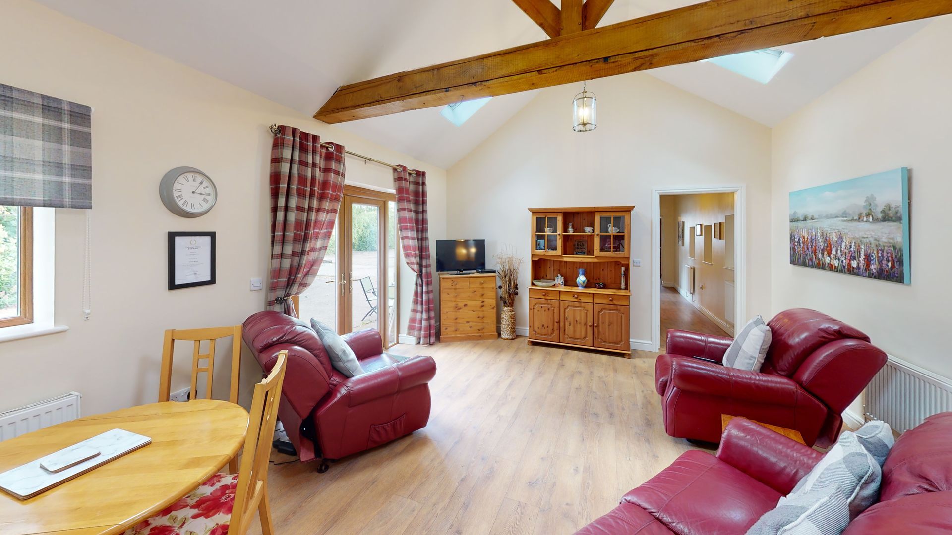 A living room with a couch , chairs , a table and a television.