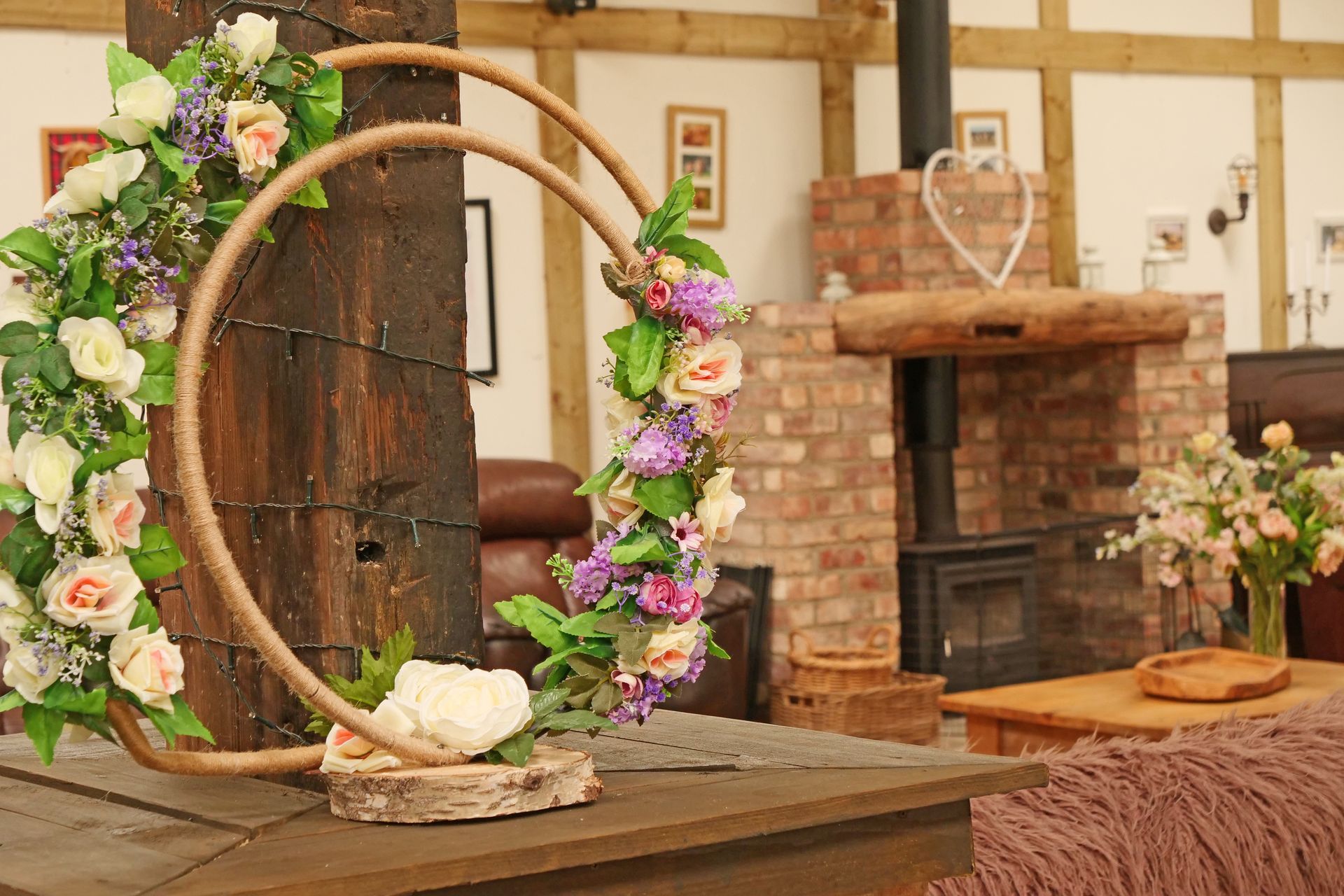 A floral wreath is sitting on a wooden table in a living room.