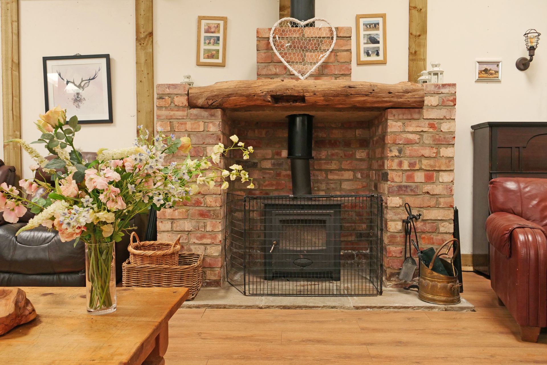 A living room with a fireplace and a vase of flowers on the table.