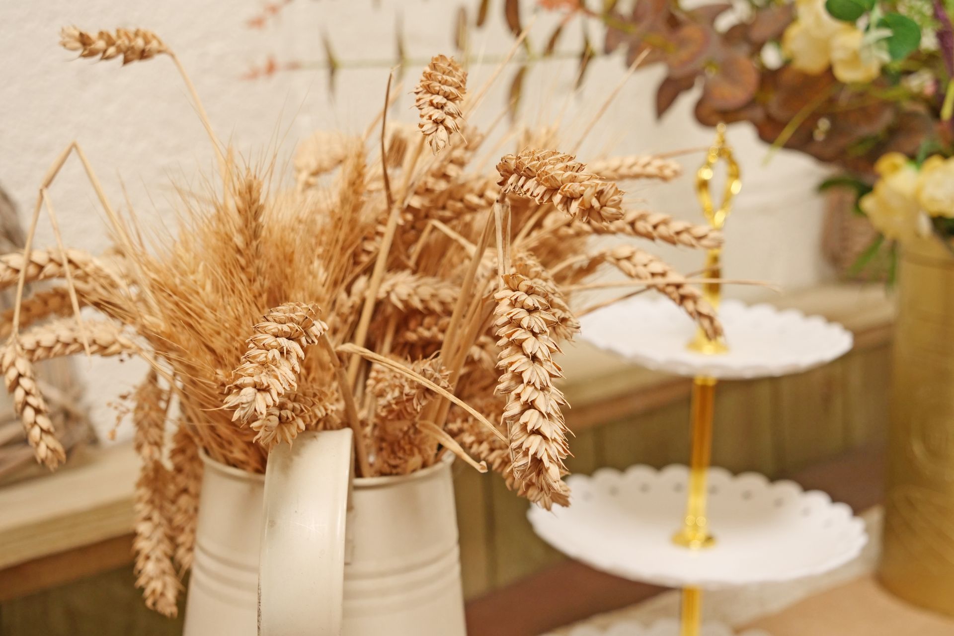 A vase filled with dried wheat ears is sitting on a table.