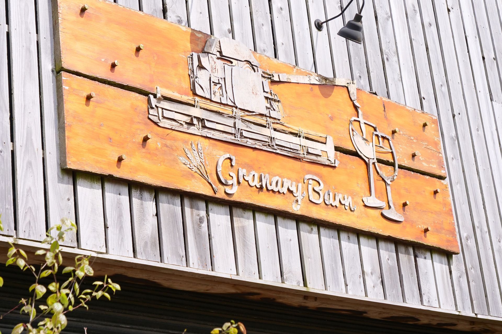 A wooden sign on the side of a building that says granary buck