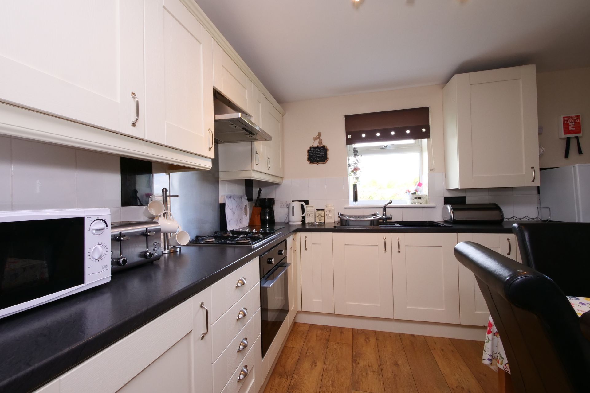 A kitchen with white cabinets and black counter tops