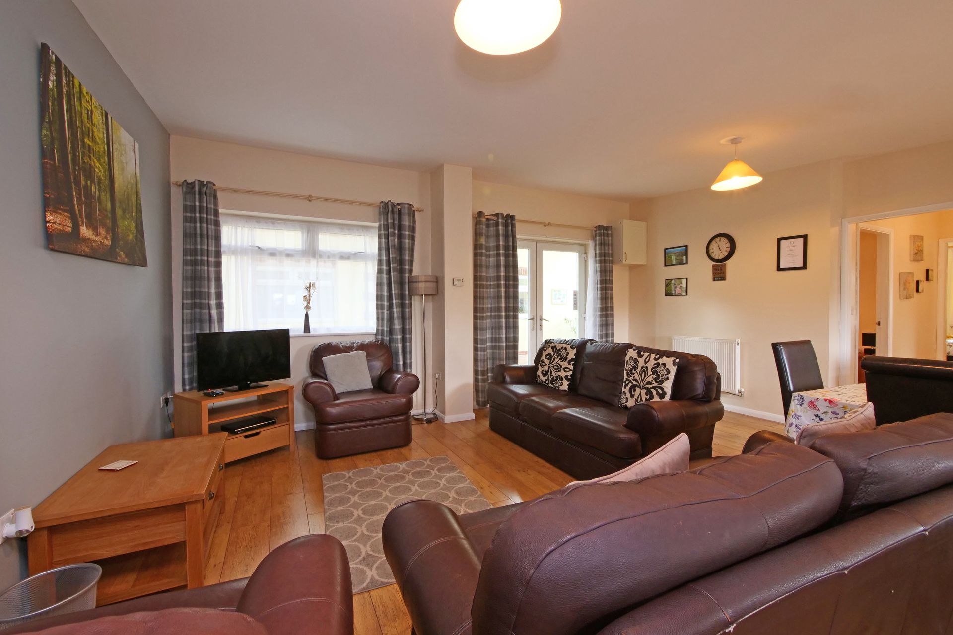 A living room with a couch , chairs , table and television.