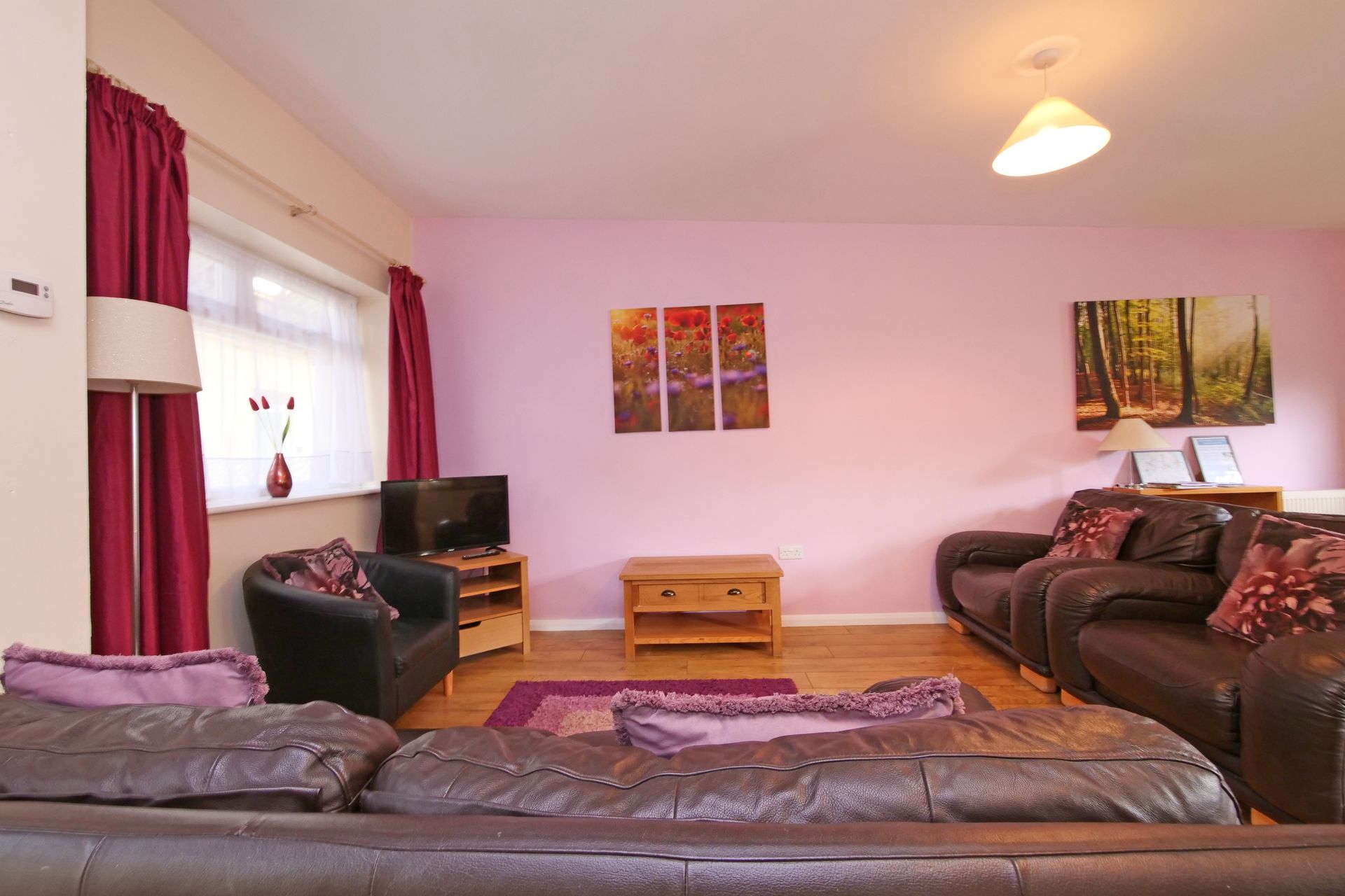 A living room with a lot of furniture and pink walls