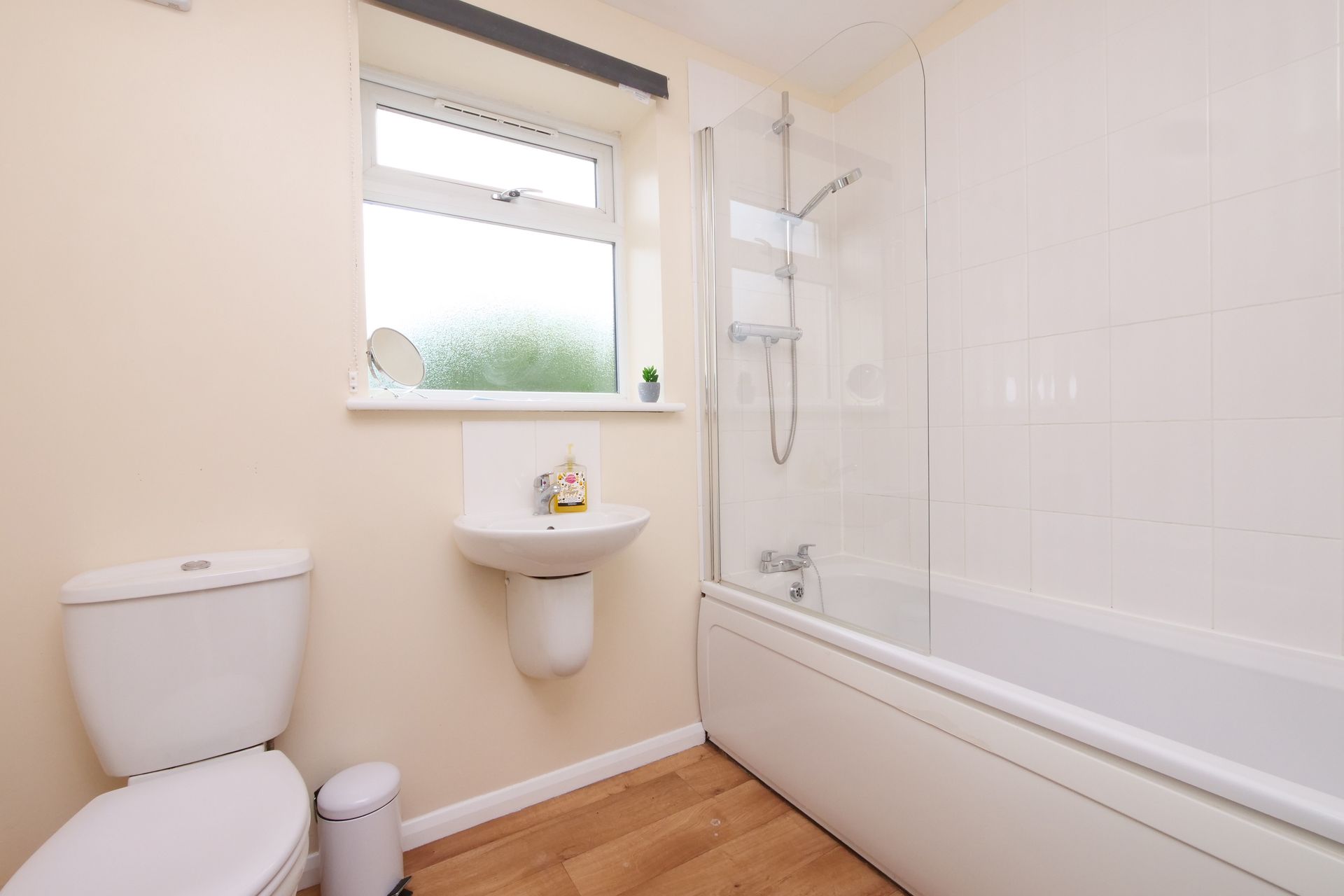 A bathroom with a toilet , sink and bathtub.