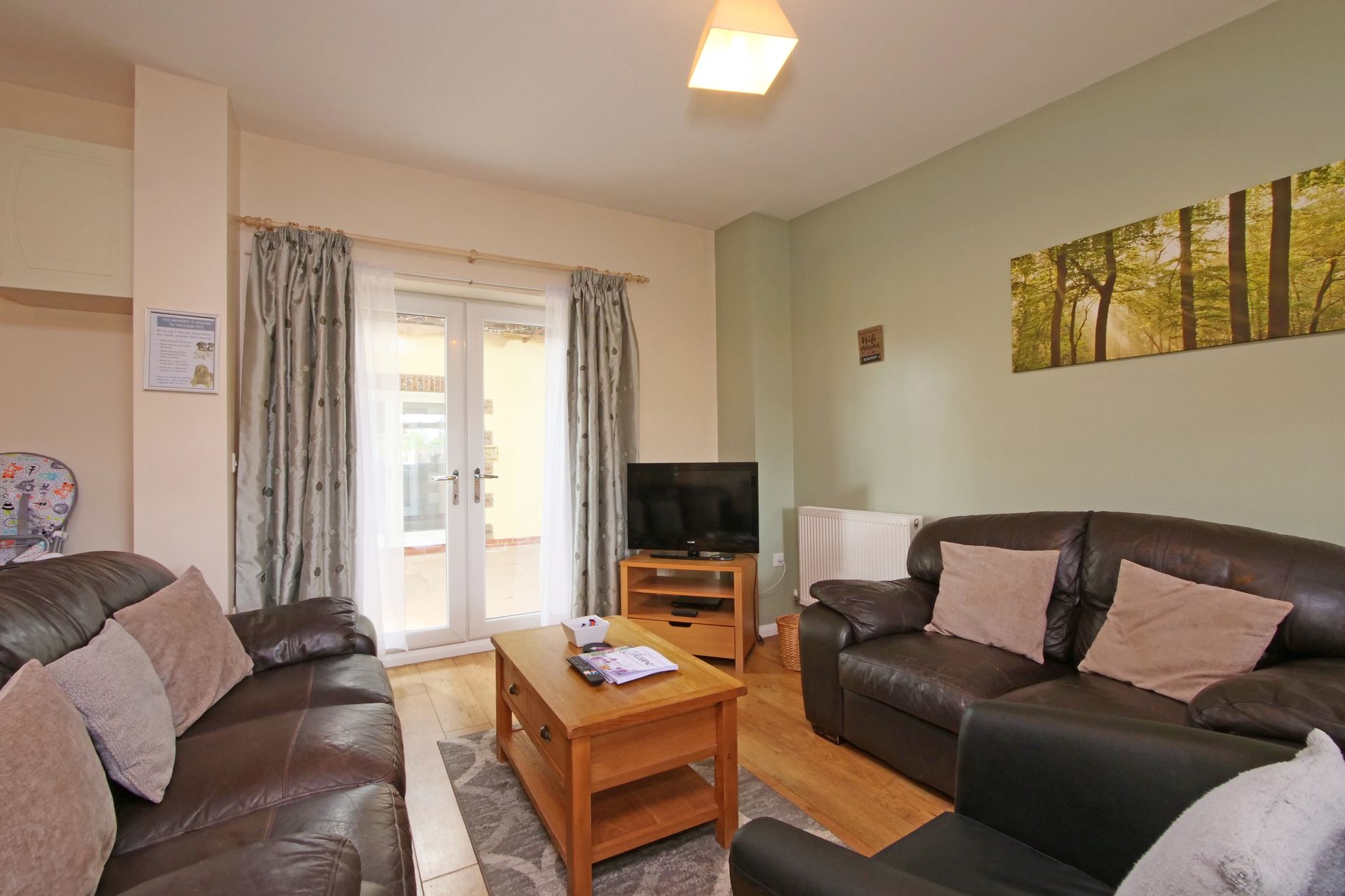 A living room with two couches , a coffee table , and a television.