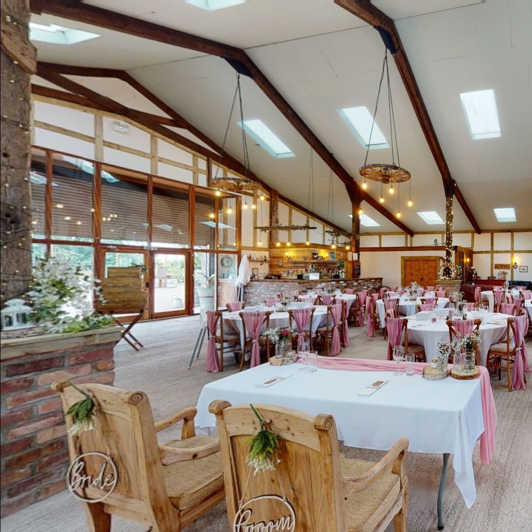 A large room with tables and chairs decorated for a wedding reception