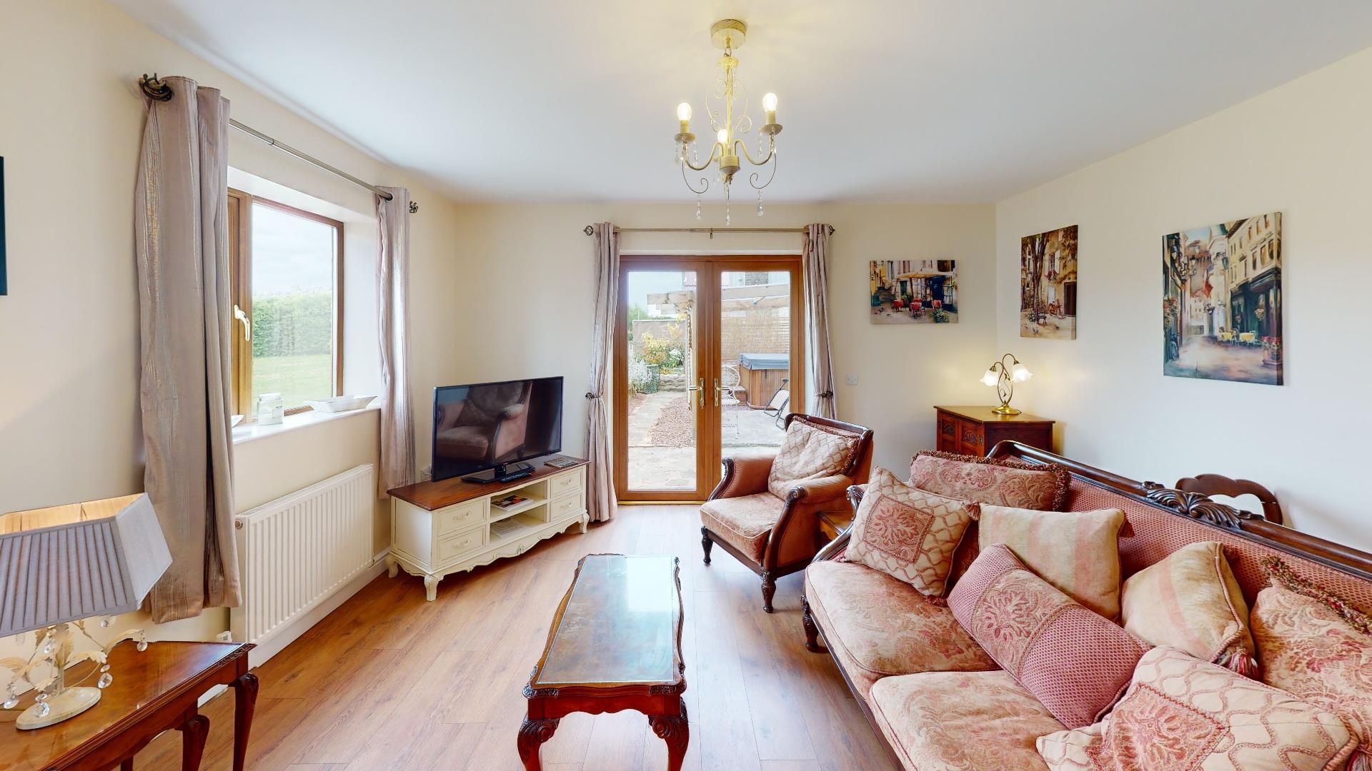 A living room with a couch , chairs , table and television.