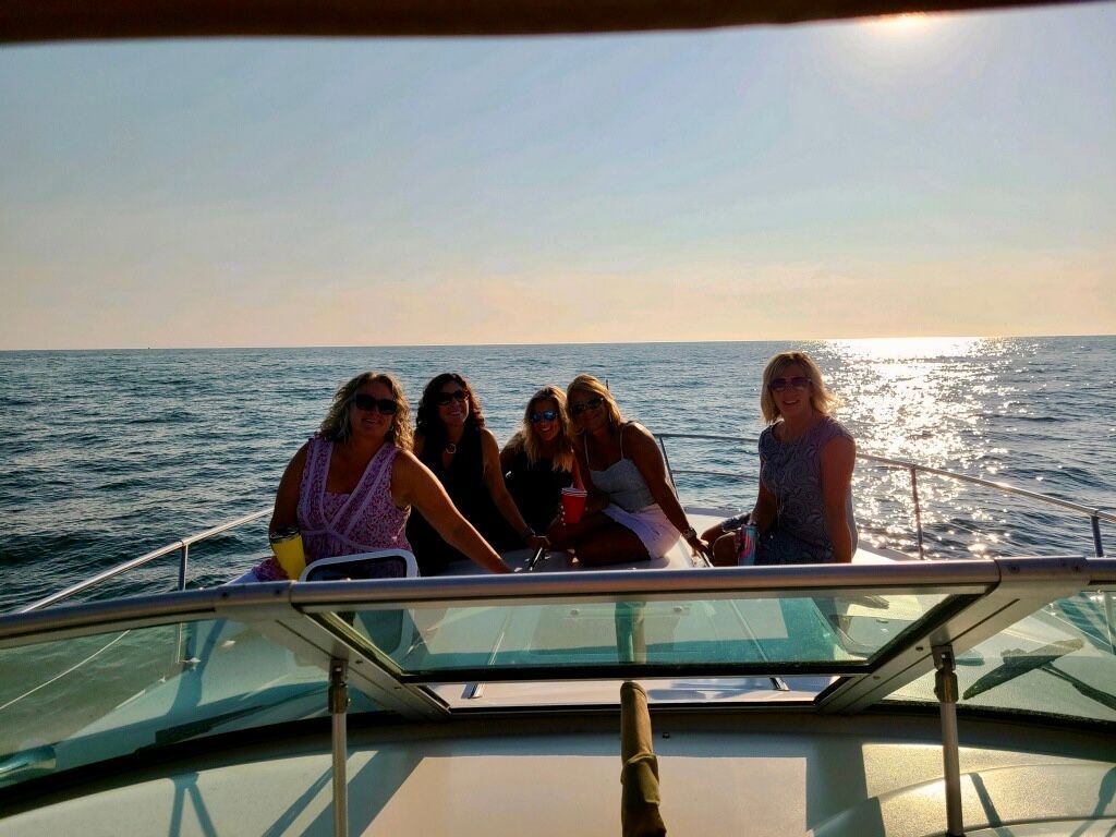Two people are toasting with champagne glasses on a boat in the ocean.