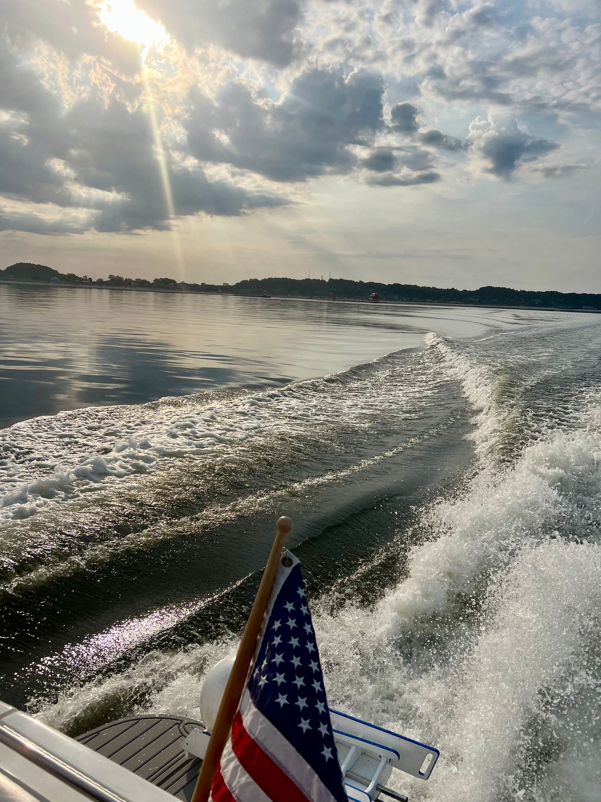 A white boat with a black canopy is floating on a lake