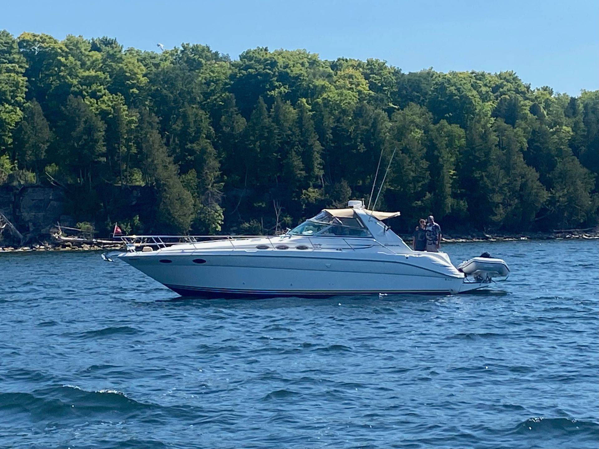 A large white yacht is floating on top of a large body of water.