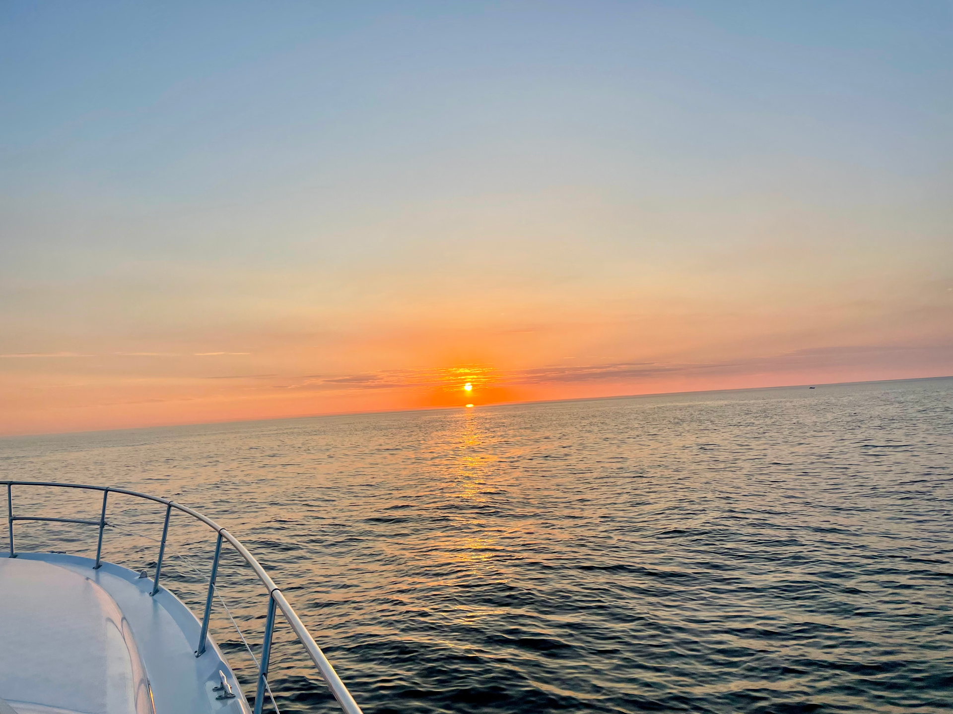 A woman is drinking wine from a glass while sitting on a boat.