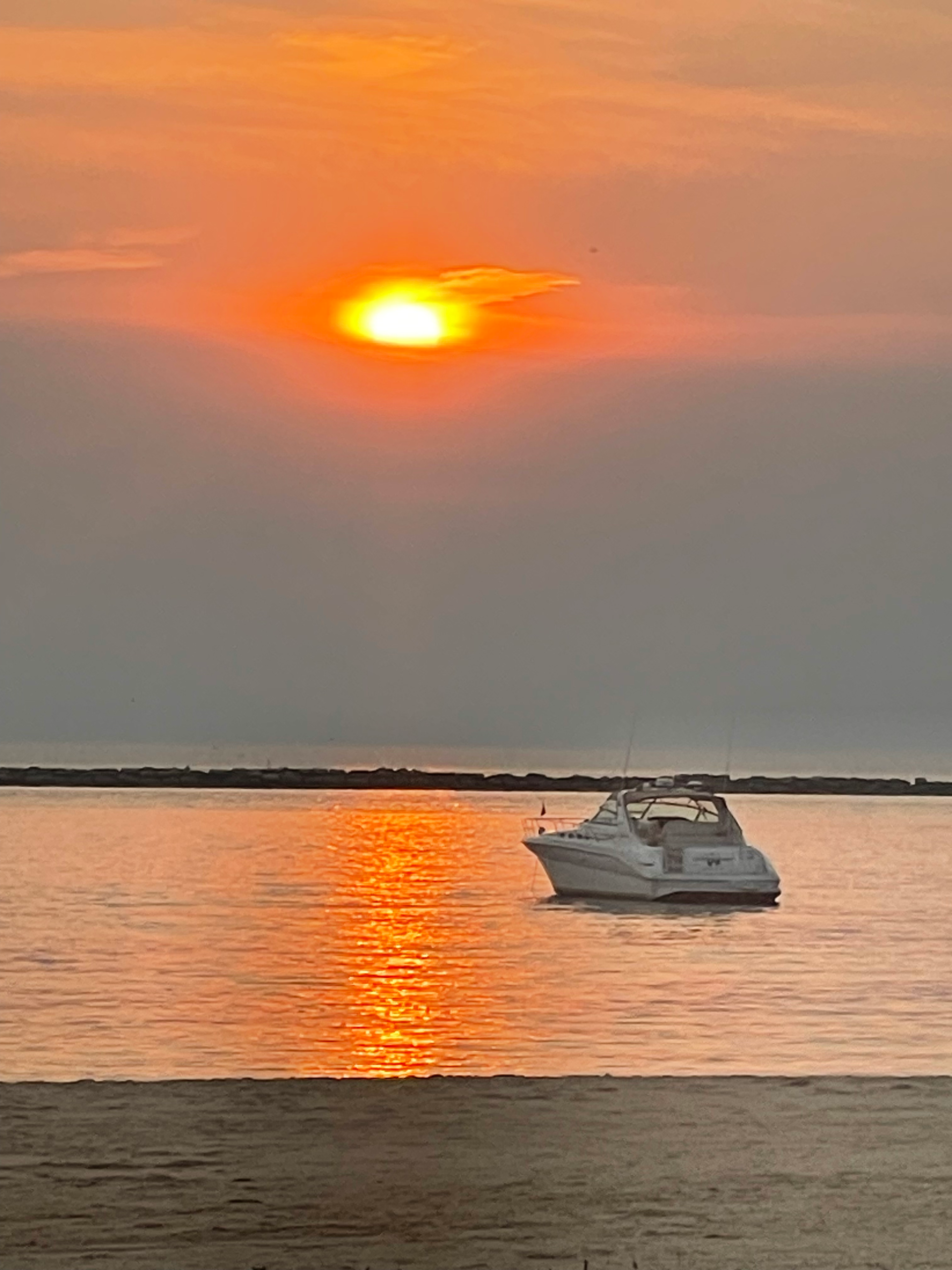 A man and a woman are sitting on the deck of a sailboat.