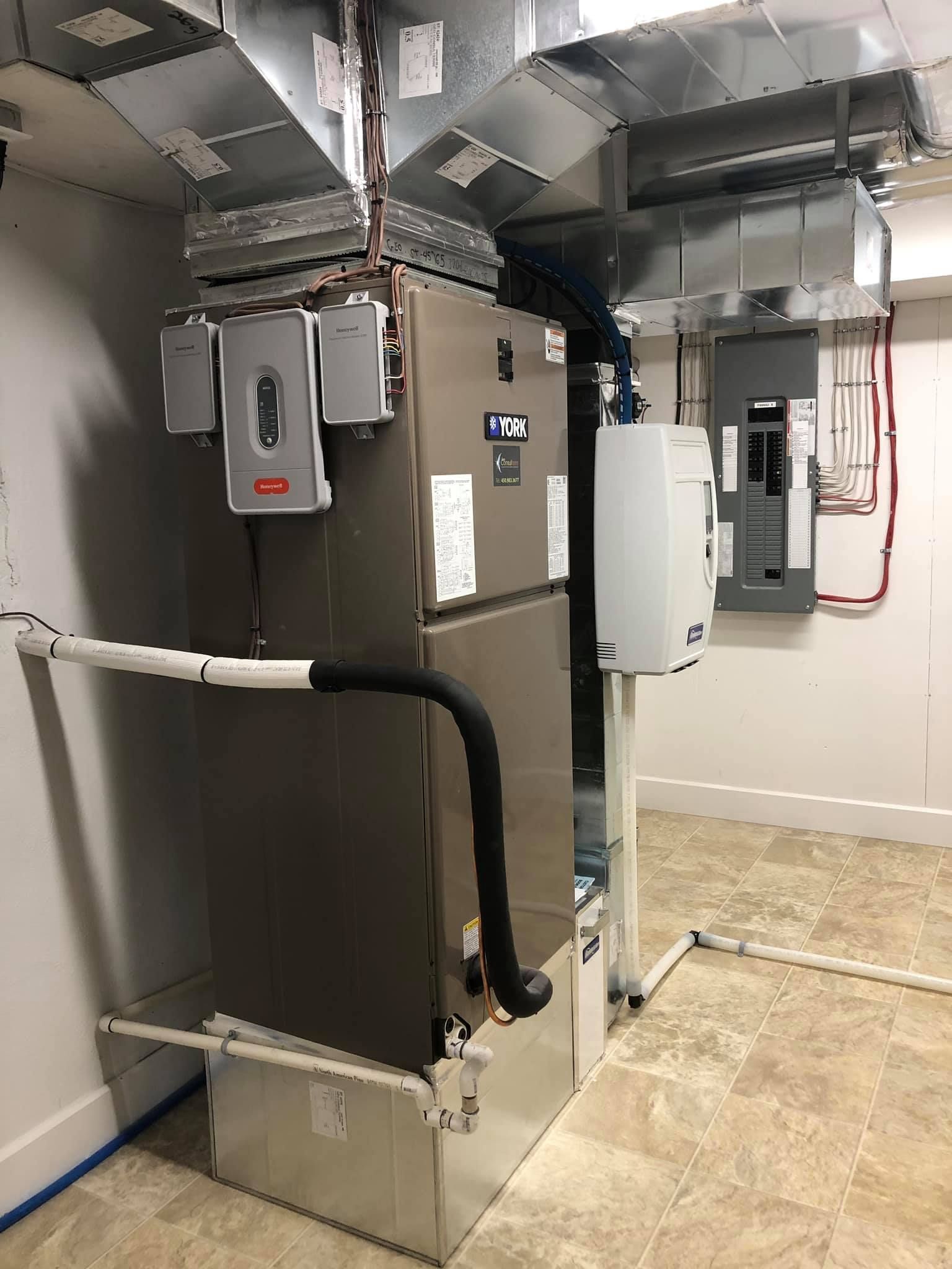 Un grand climatiseur se trouve dans un sous-sol à côté d'un mur.