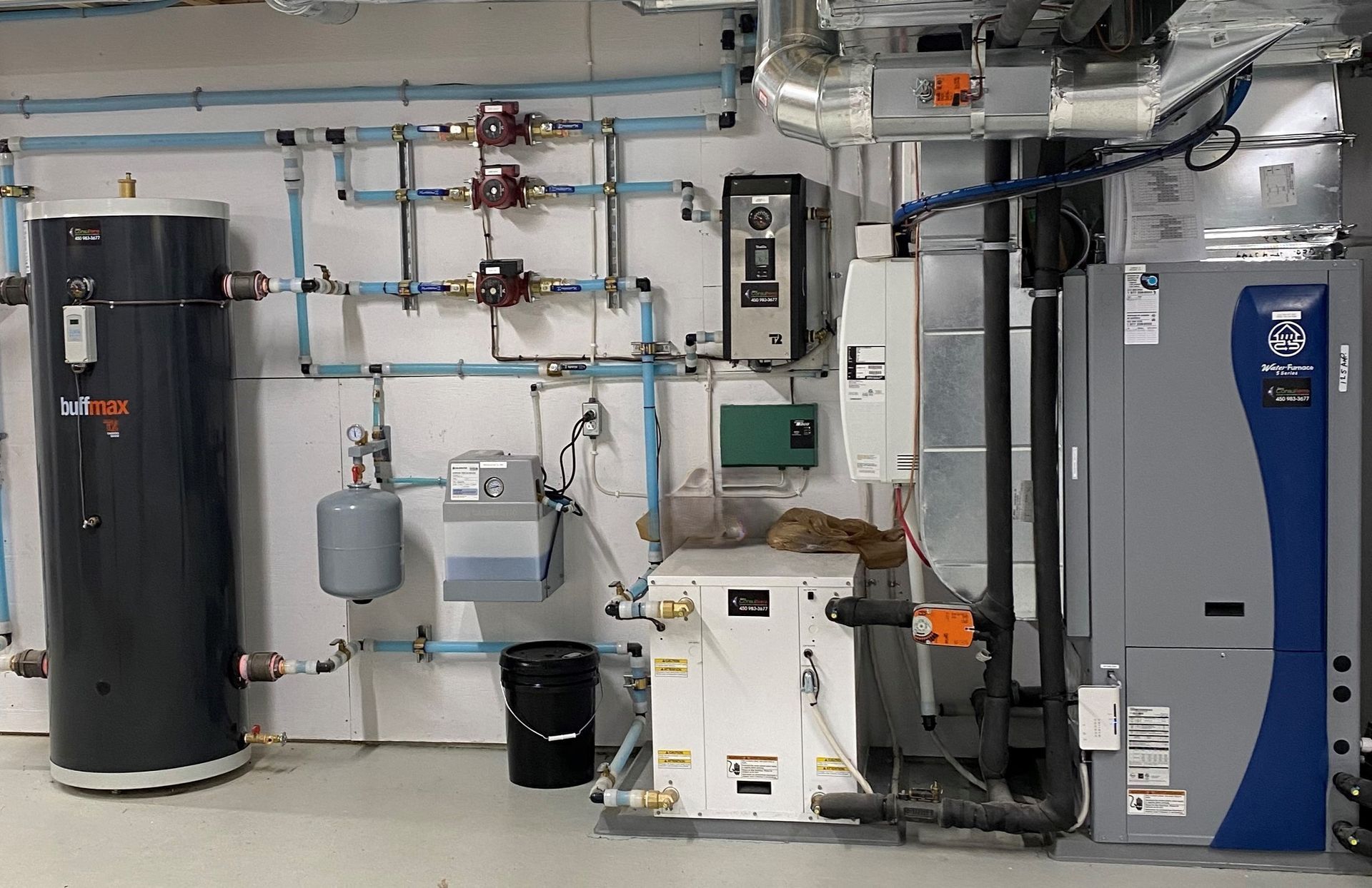 Une pièce avec beaucoup de tuyaux et un chauffe-eau