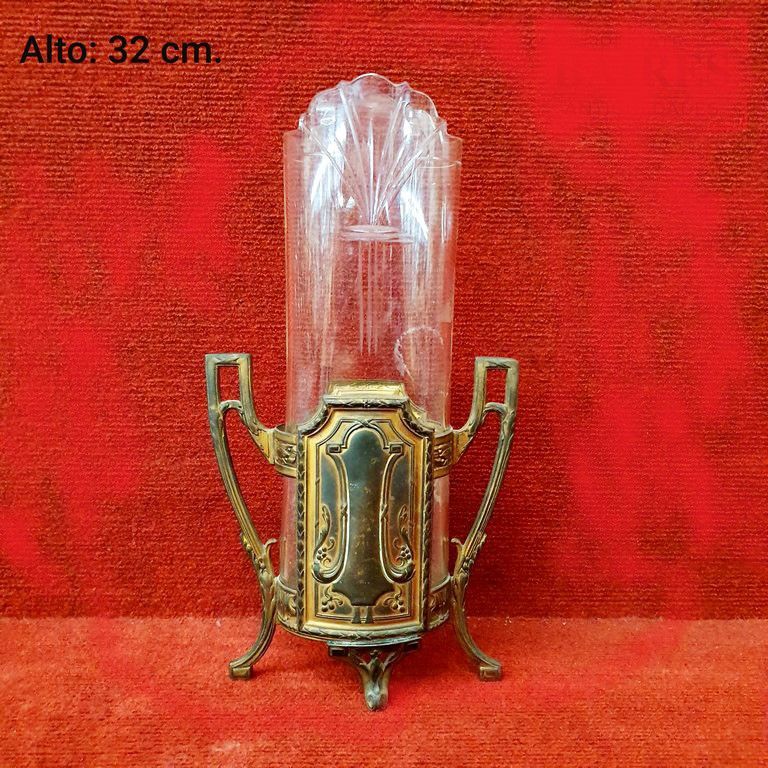 Candelabro antiguo de cristal y latón, ornamentado en dorado y transparente, de 32 cm de alto, sobre fondo rojo.
