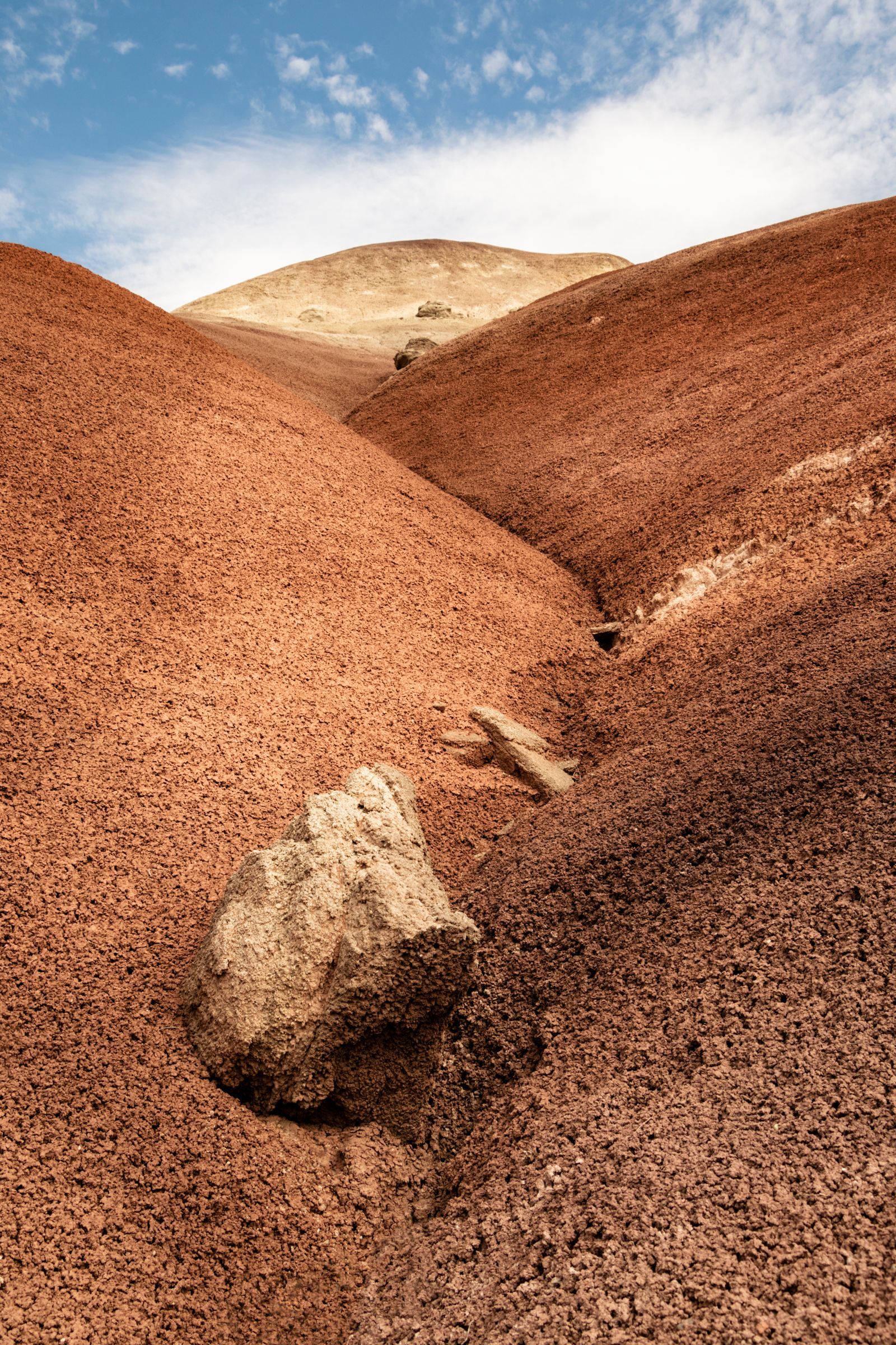 A large rock is sitting on top of a hill in the desert.