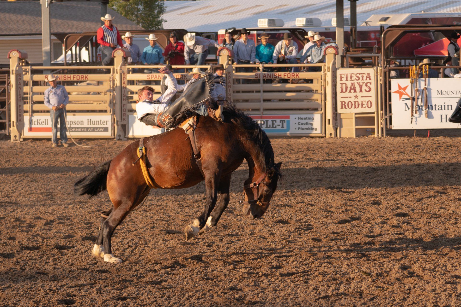 A man riding a horse in a rodeo arena with a sign that says fiesta days rodeo