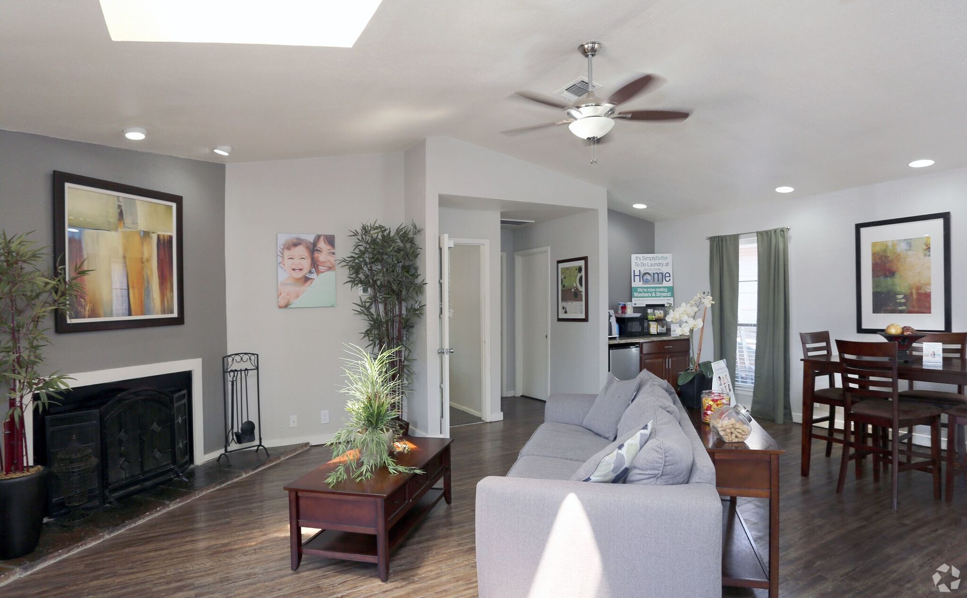 Living room with fireplace, gray sofa, dark wood furniture, and dining area.