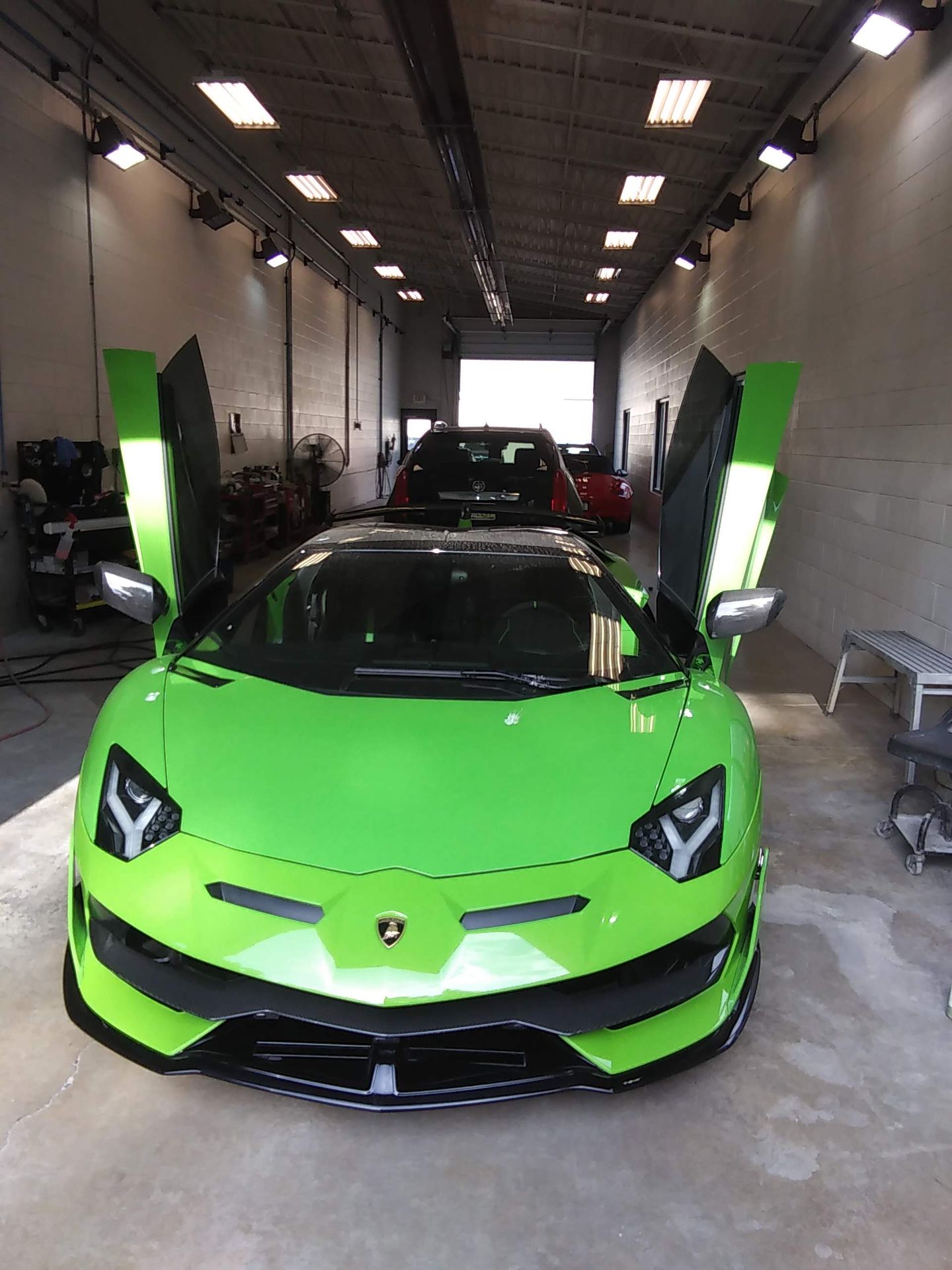 The trunk of a corvette with a red rug and boxes