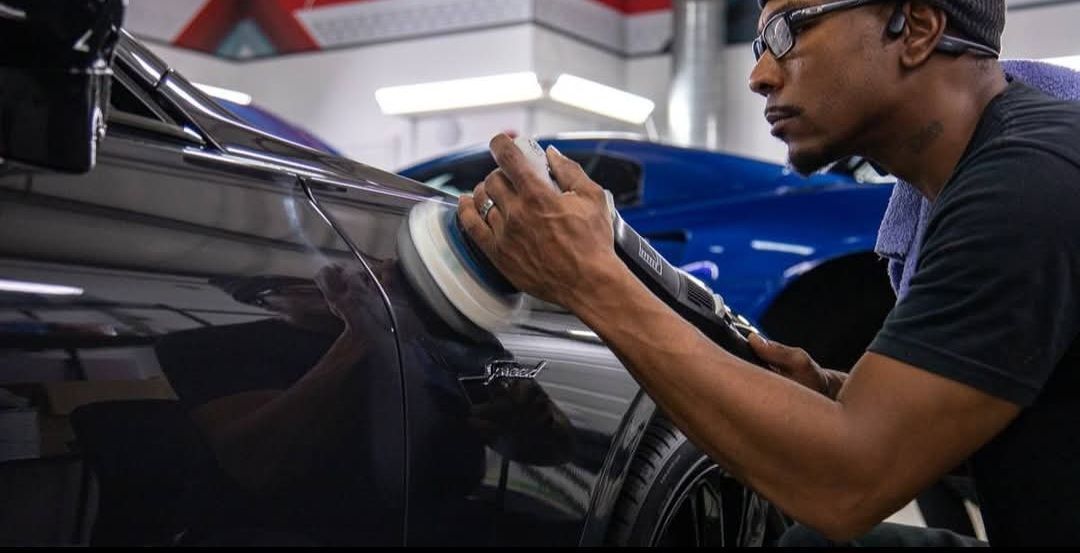 The trunk of a corvette with a red rug and boxes