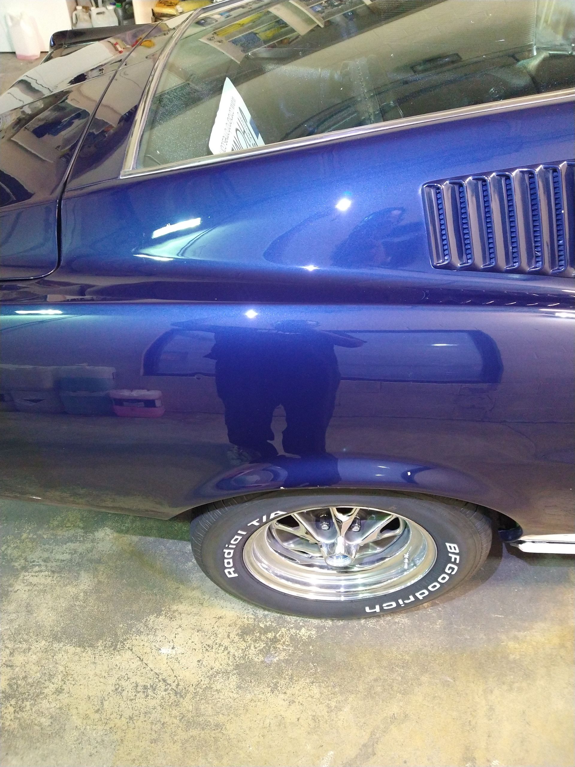 A blue mustang is parked in a garage.