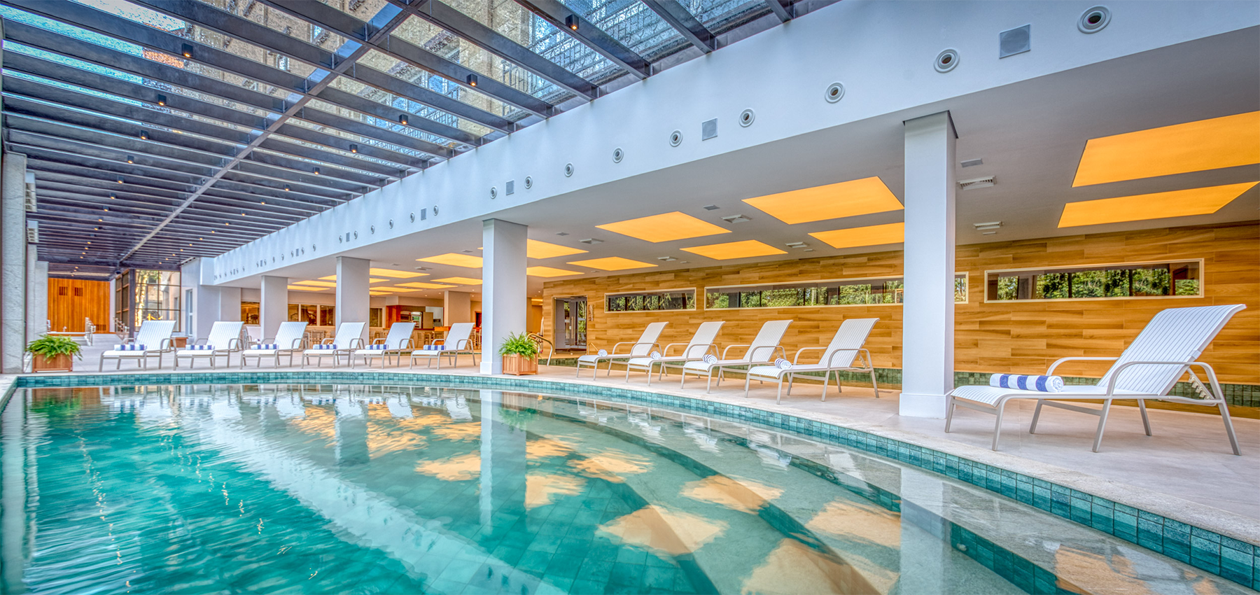 Há uma grande piscina coberta com cadeiras ao redor.