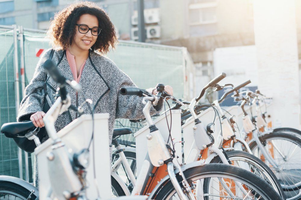 Mulher jovem retirando bicicletas para utilizar através do formato de economia colaborativa