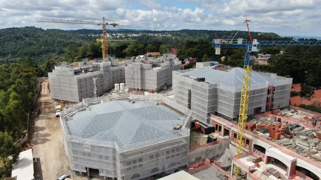 Uma vista aérea de um grande edifício em construção com guindastes.