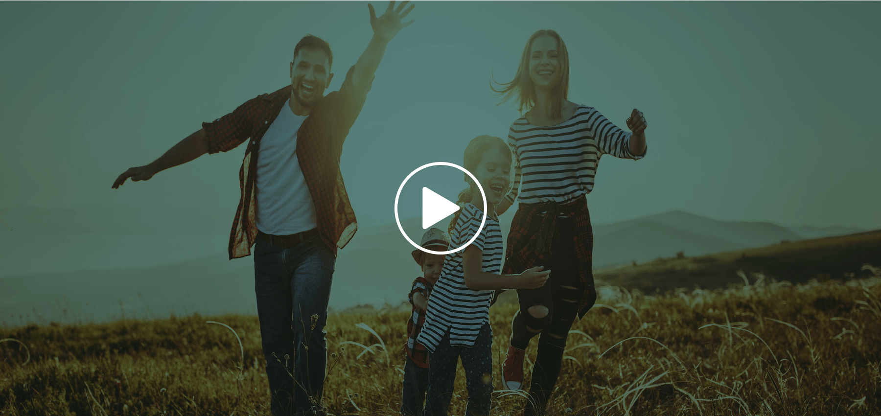 Uma família está caminhando por um campo gramado.