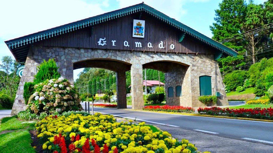 Um arco de pedra que conduz a um edifício com flores na frente.