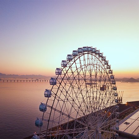 Uma grande roda gigante com vista para um corpo de água