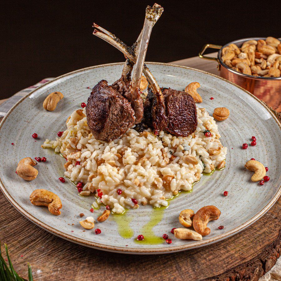 Um prato de comida com arroz e carne sobre uma mesa de madeira.