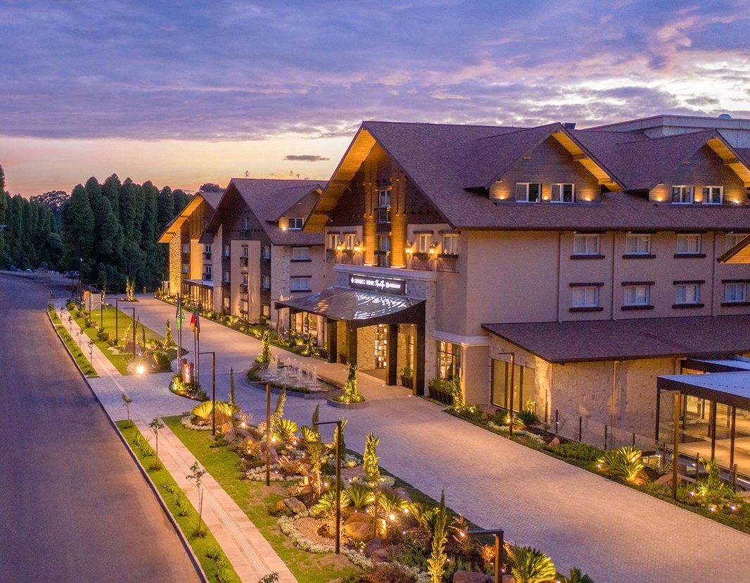 Uma vista aérea de um grande edifício com uma entrada de automóveis que leva até ele.