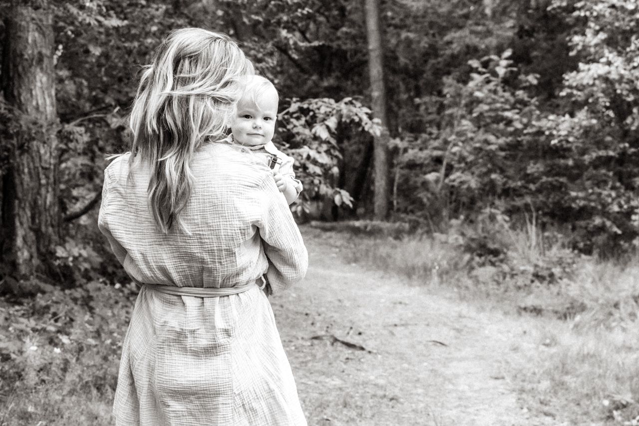 Een vrouw houdt een baby in haar armen op een zwart-witfoto.