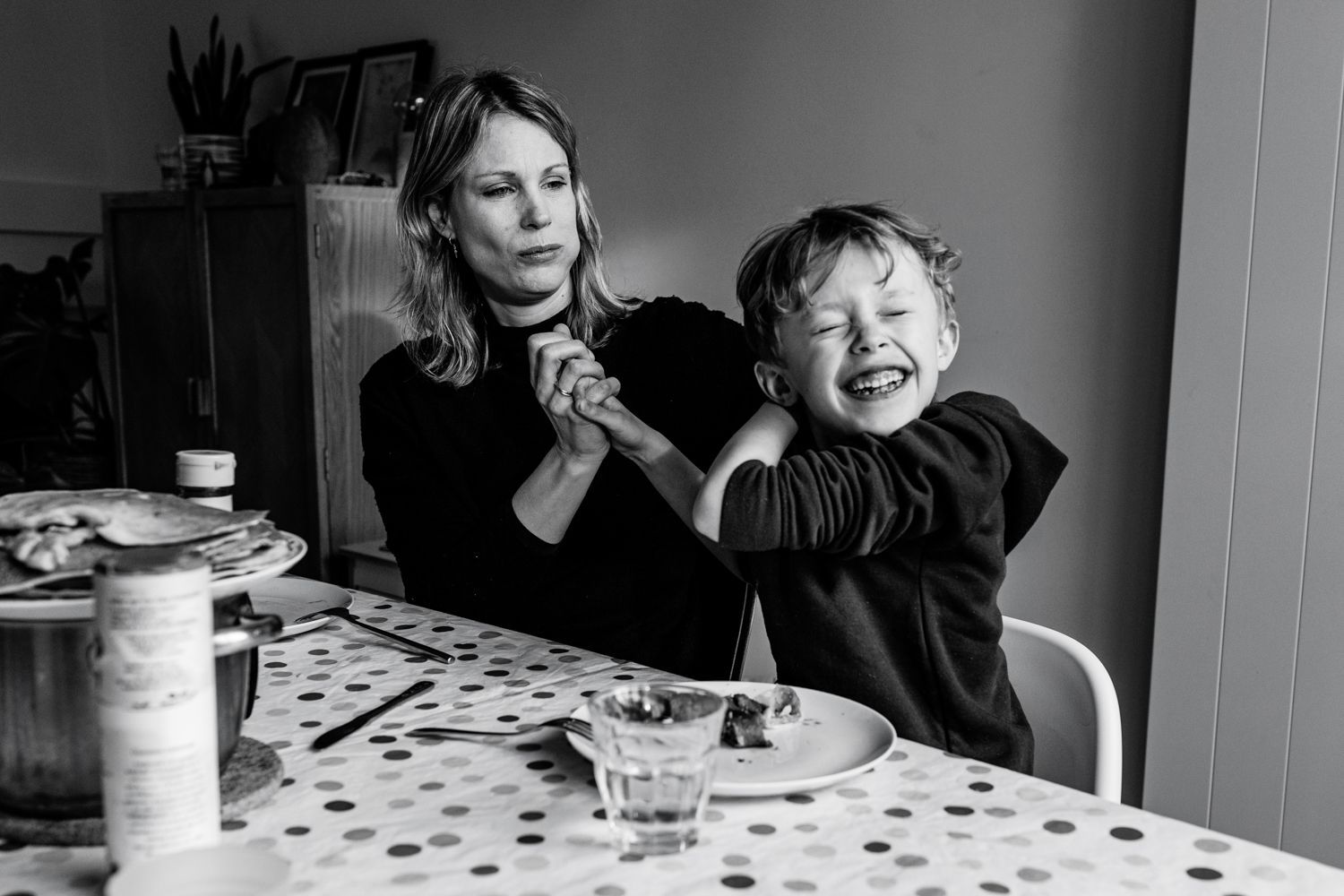 A black and white photo of a woman and a child sitting at a table.