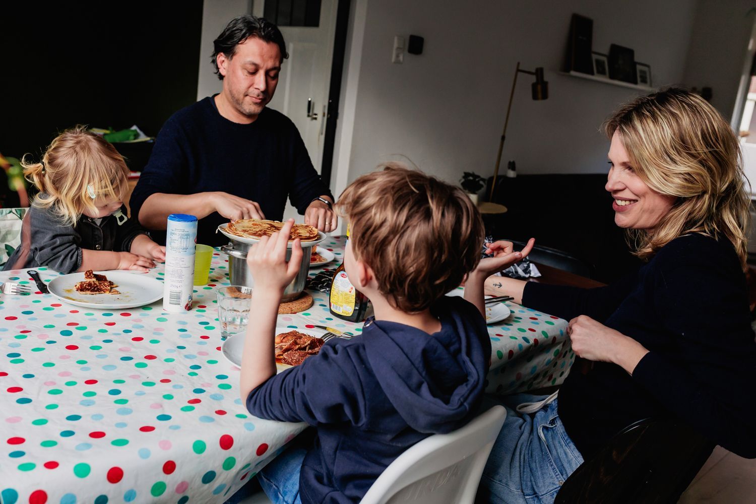 A family is sitting at a table eating food.