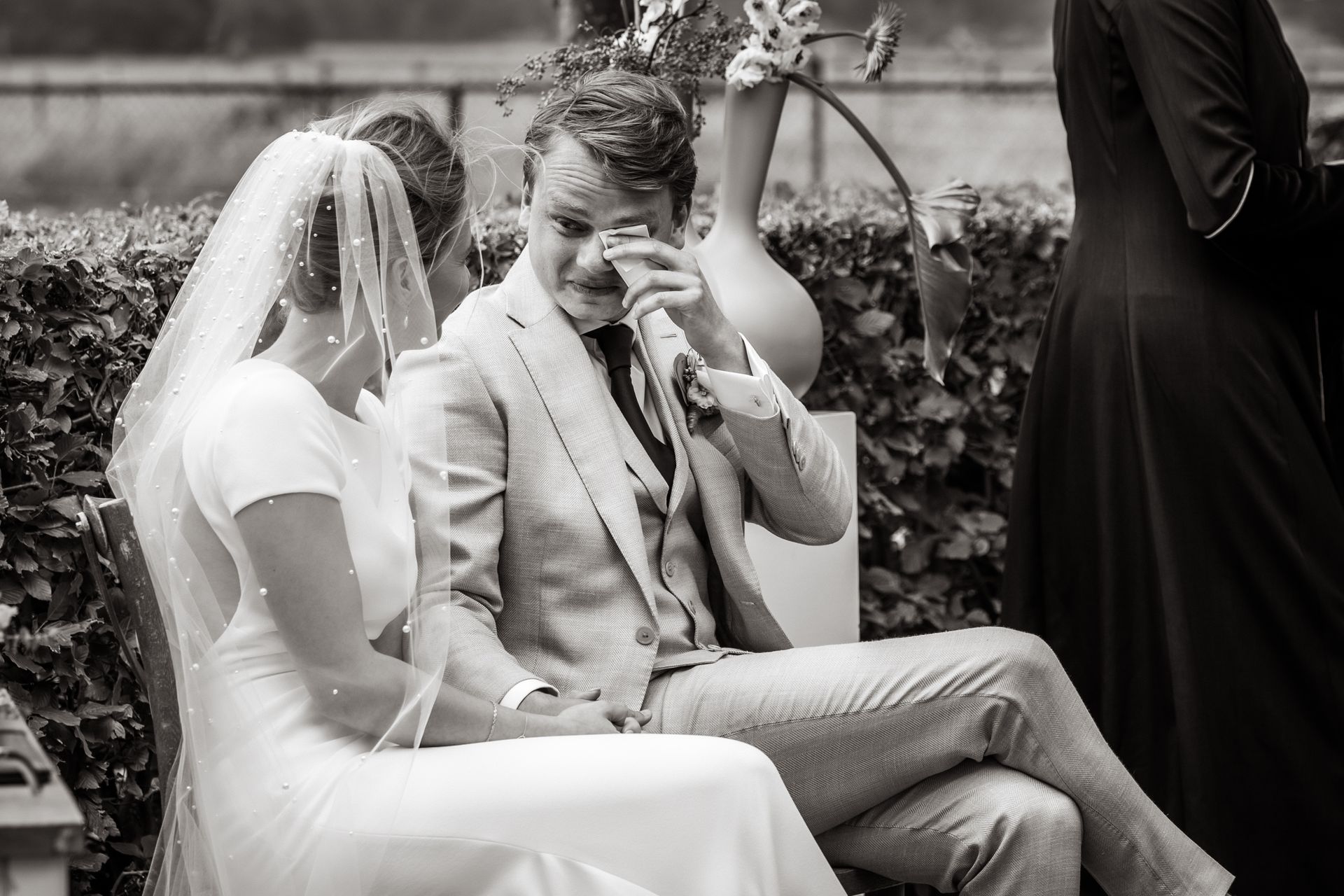 Een zwart-witfoto van een bruid en bruidegom die naast elkaar zitten.