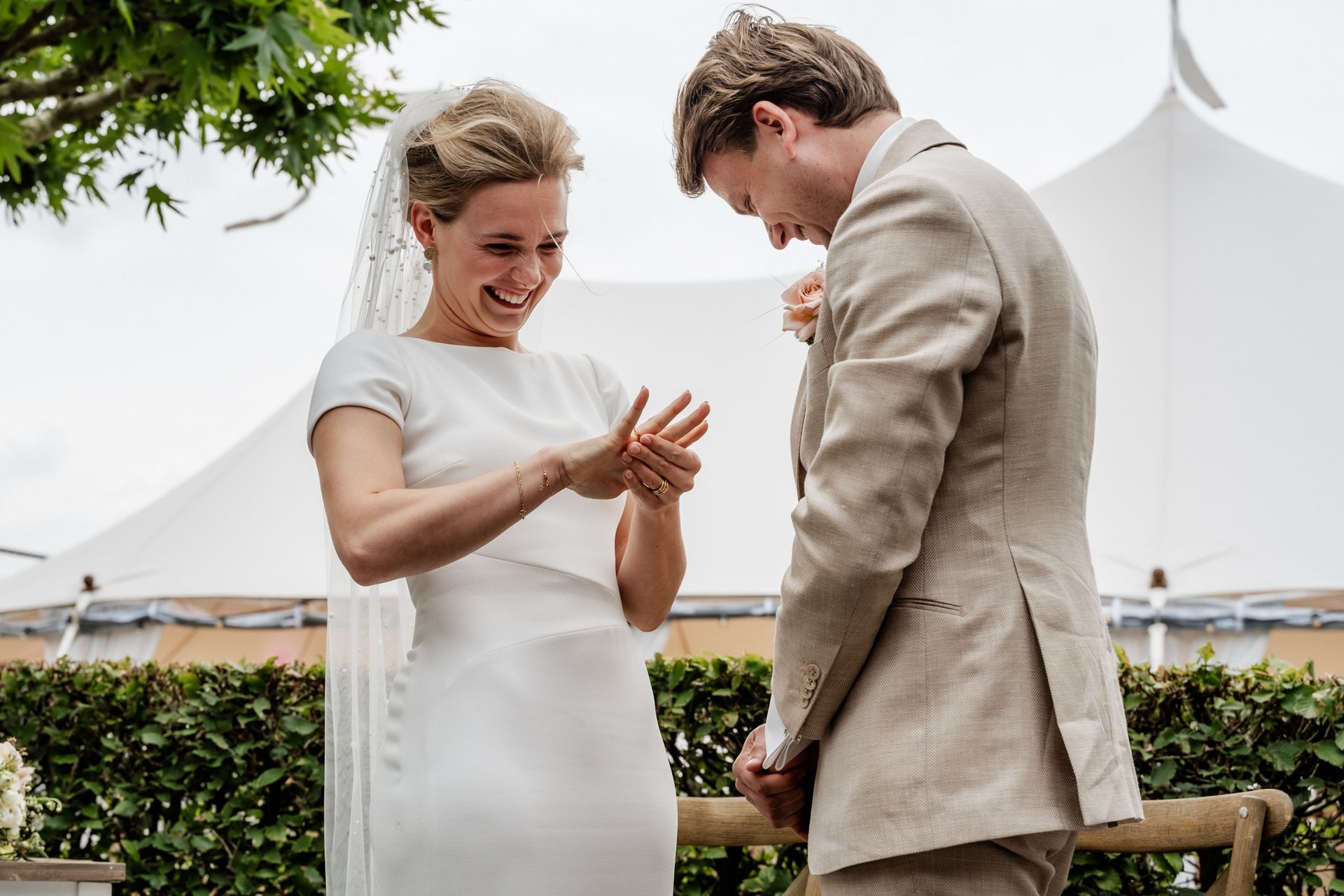 Een bruid en bruidegom gaan trouwen voor een witte tent.