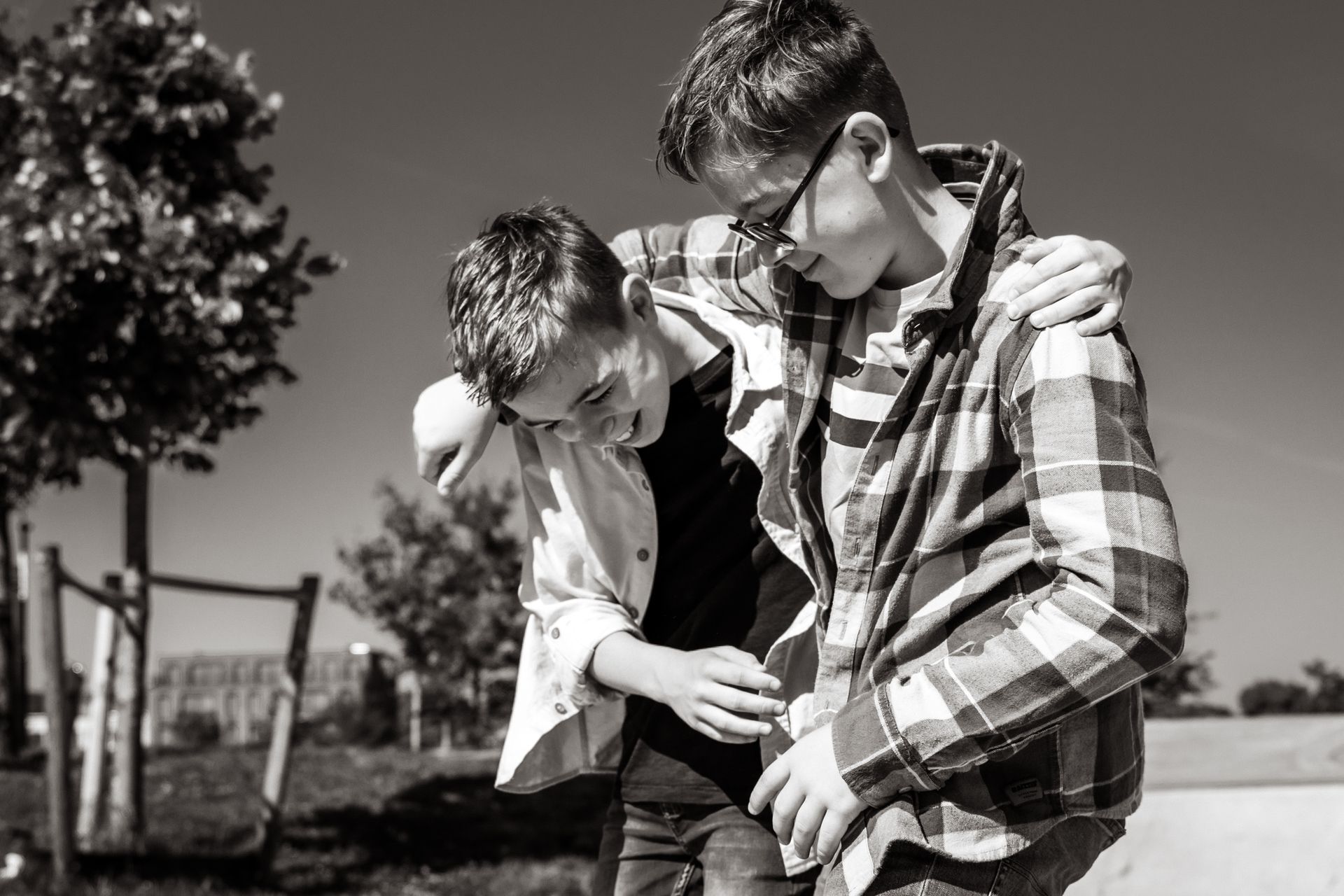 Een zwart-witfoto van twee jongens die elkaar omhelzen.