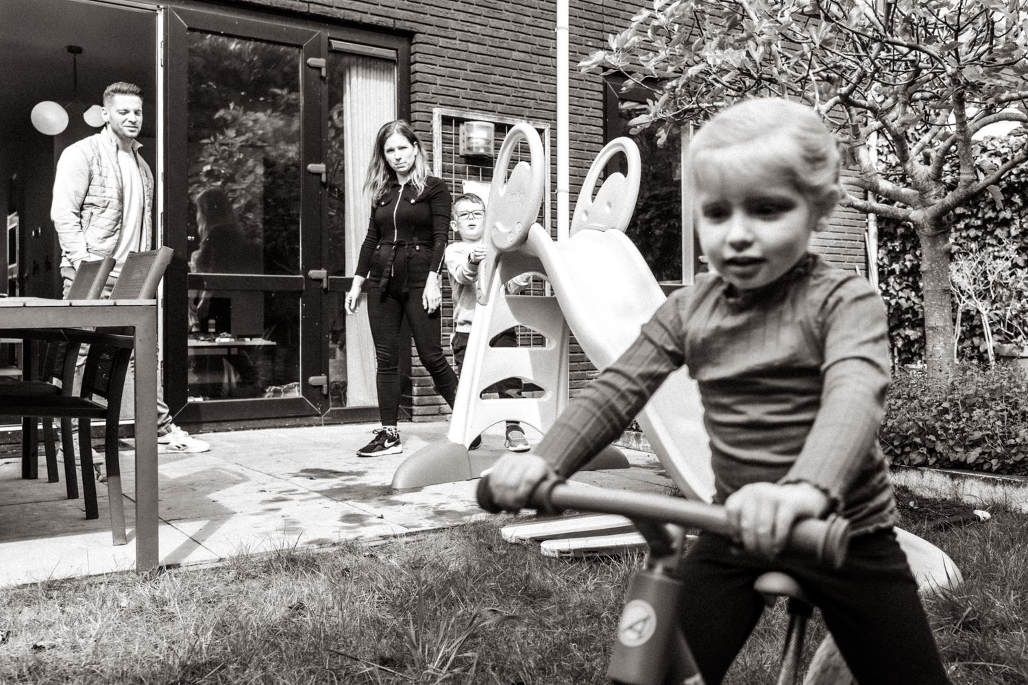 Een klein meisje fietst op een zwart-witfoto.