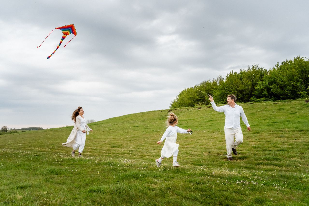 Een gezin vliegert in een veld.