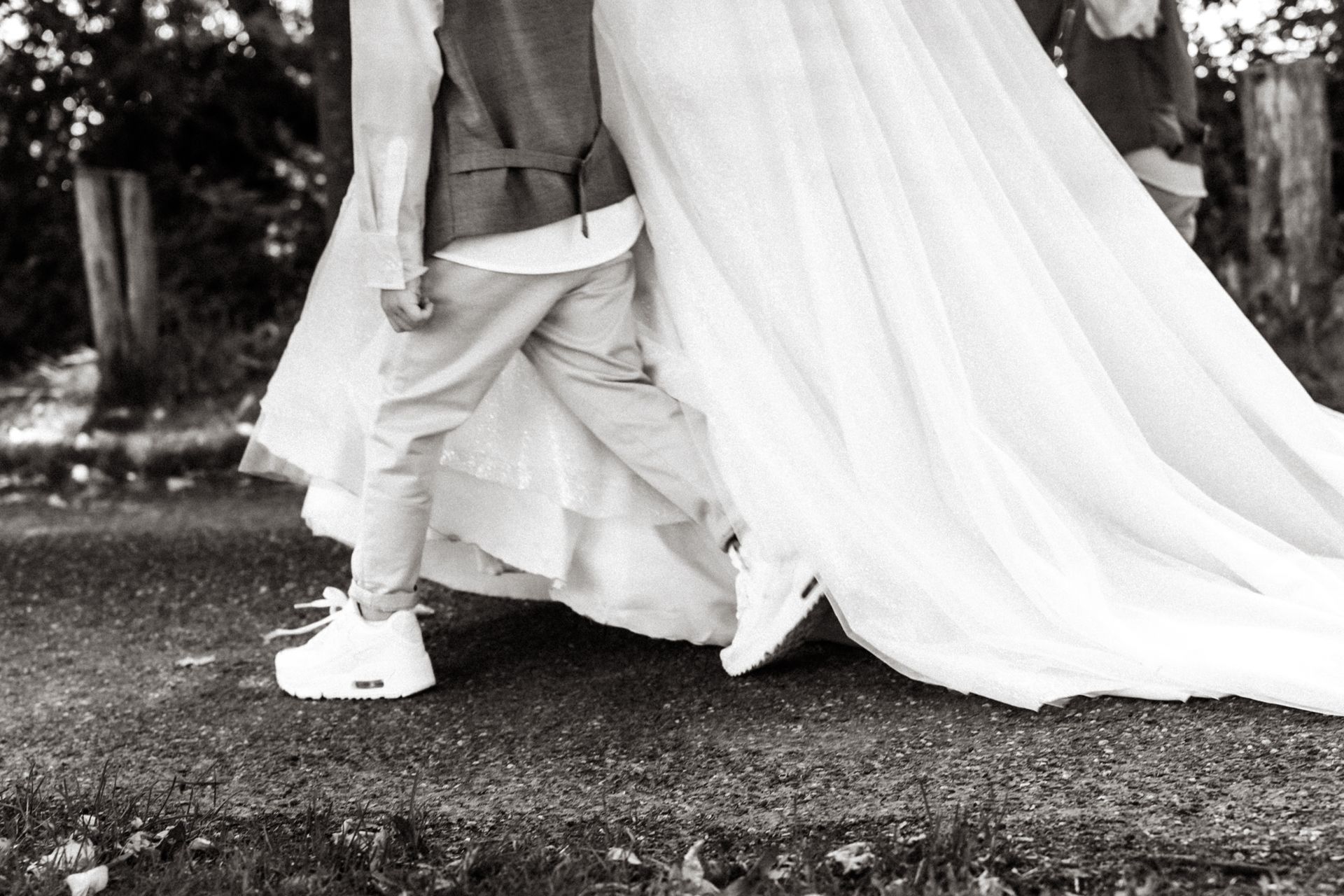 Een zwart-witfoto waarbij een klein kind naast de bruid loopt.