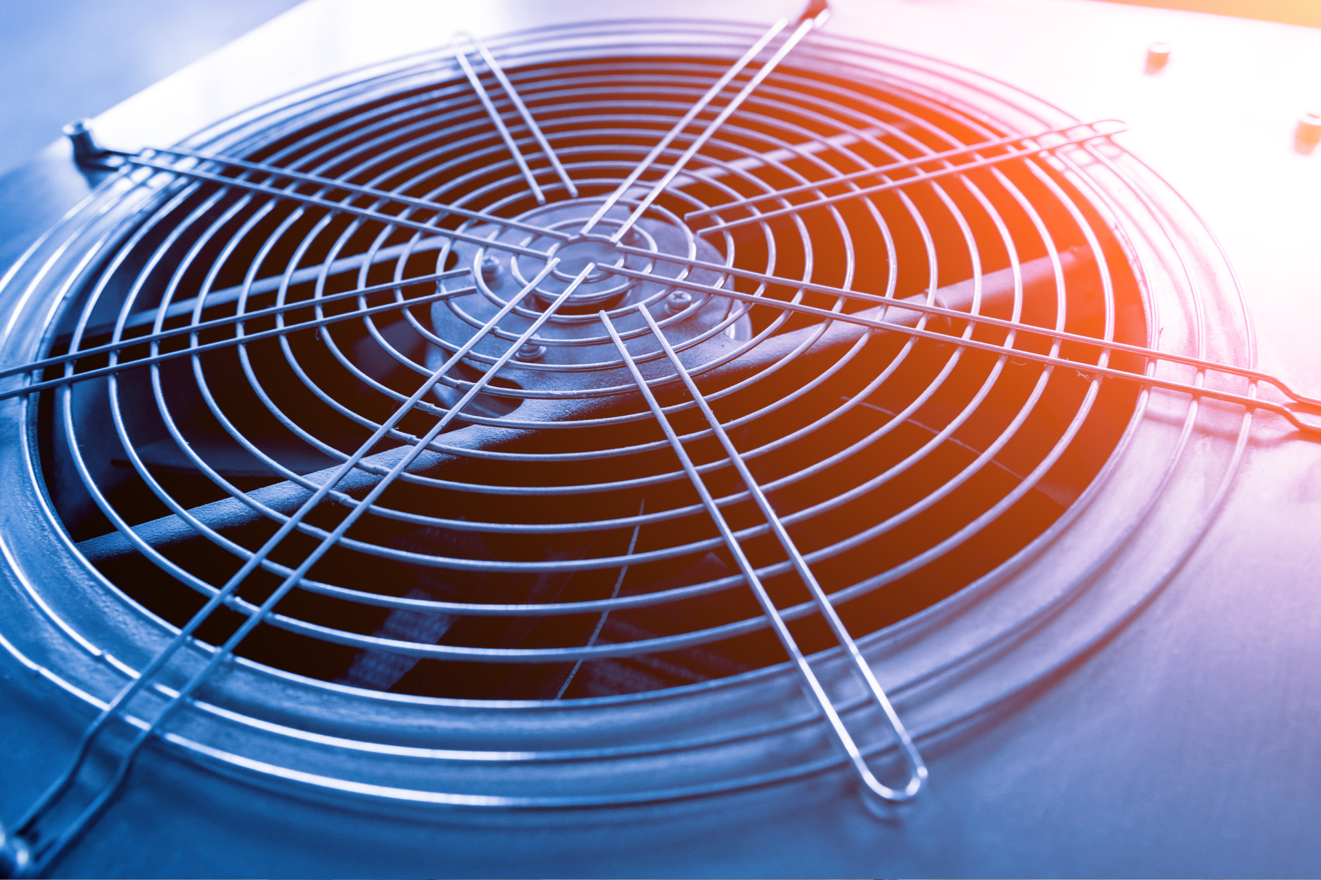 A close up of a metal fan on a blue background.