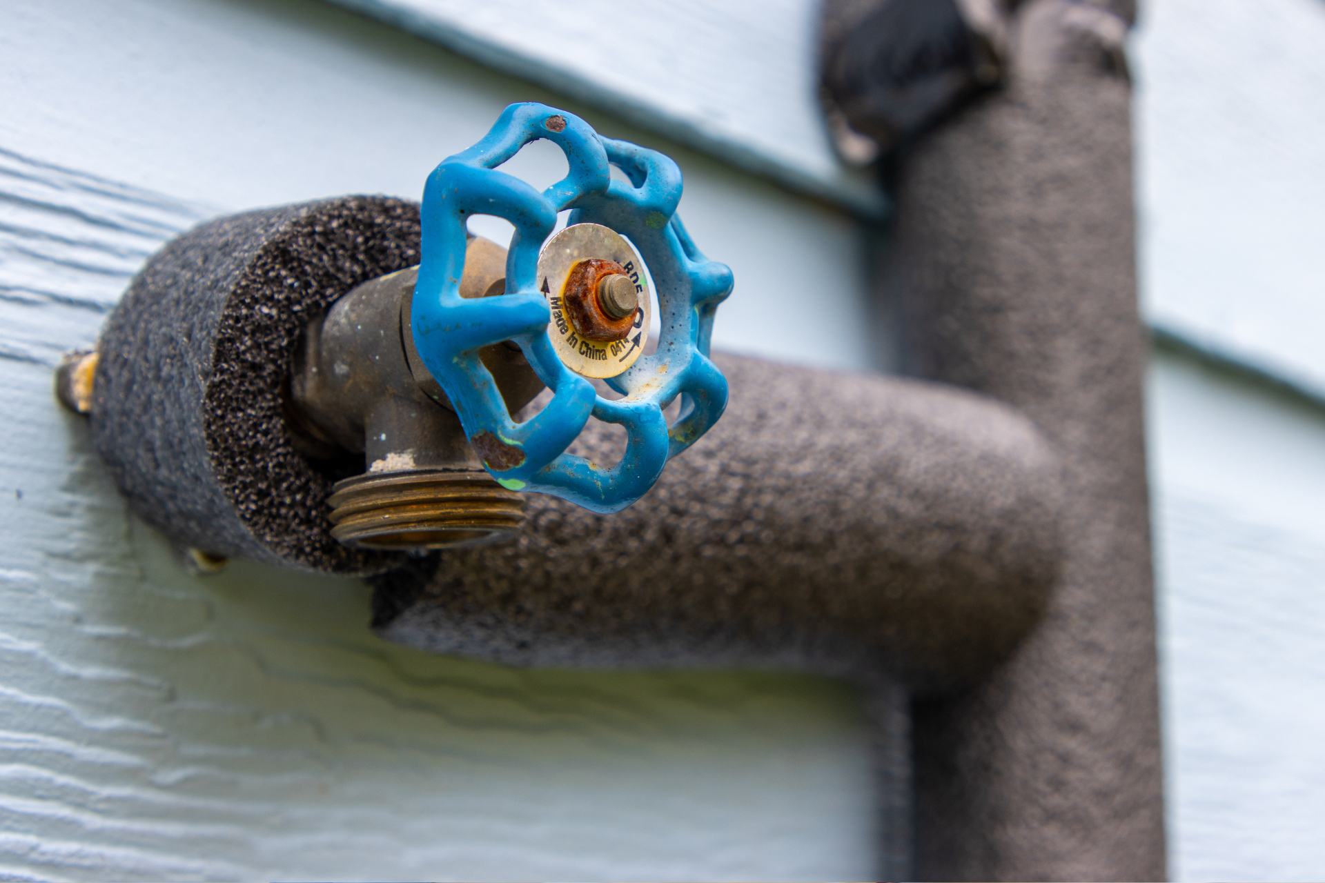 A close up of a hose with a blue handle on it.