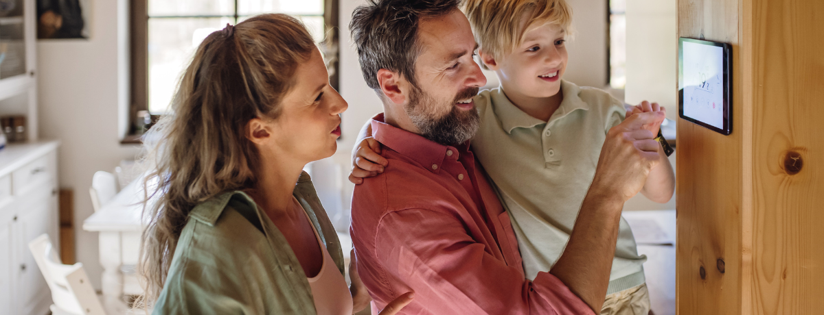 A family is looking at a tablet in a living room.