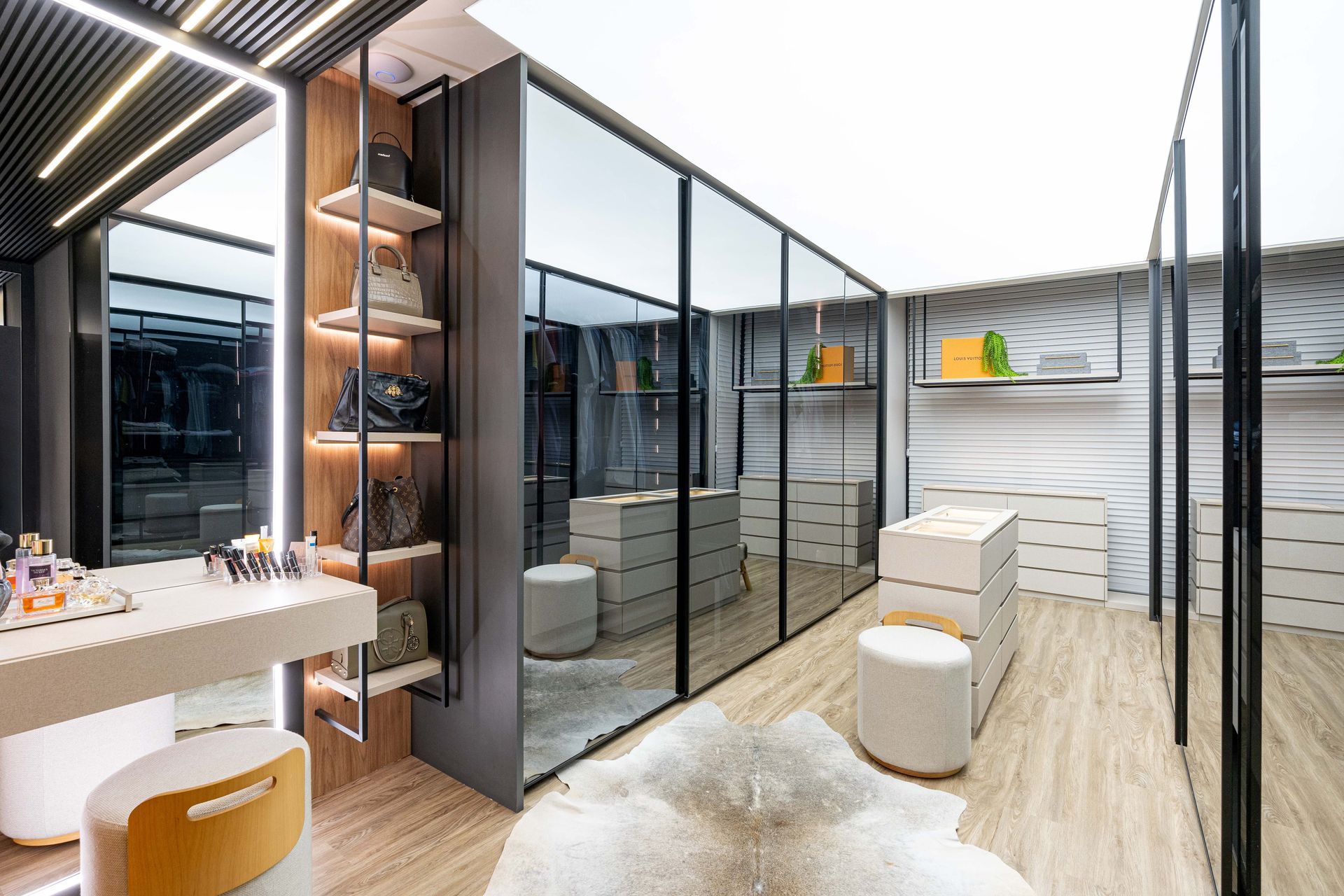 Um closet moderno com paredes espelhadas, penteadeira, prateleiras e um tapete de pele.