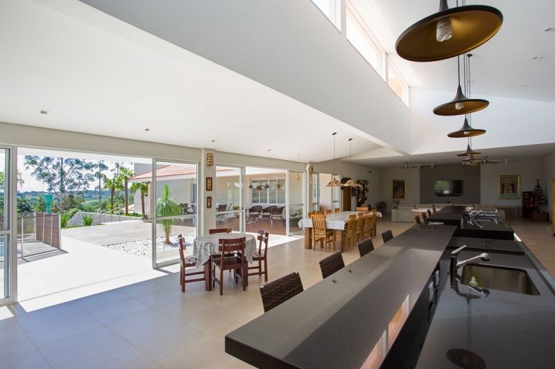 Cozinha espaçosa e aberta com vista ampla, balcão longo e área de jantar com vista para um pátio.