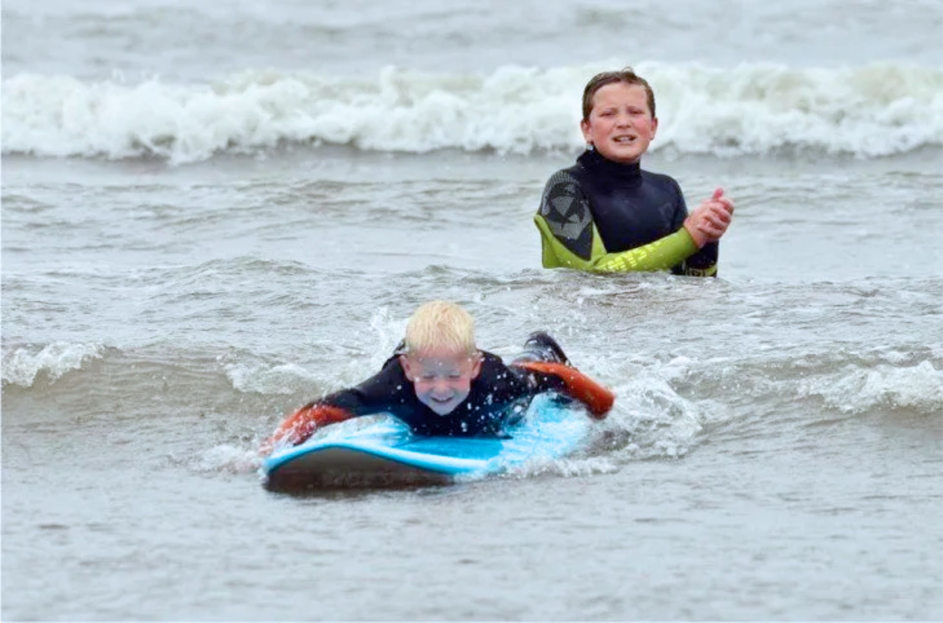 Kids learning to surf at Westward Ho! Devon. Stand up on the board and watch the sea underneath you. Learning to surf is perfect here.