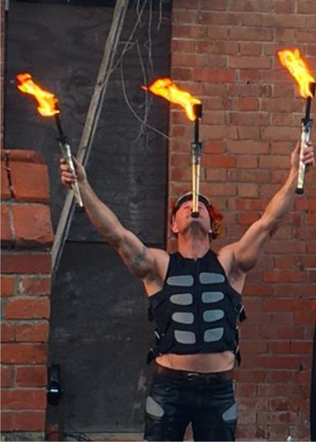 Merlin Cadogan juggling fire outside seafield house in Westward Ho!